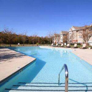 A photo that overlooks the length of the pool at Riverwalk Apartments from the ladder in.