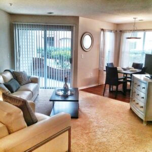A living room with a patio out of the patio doors with green walls.