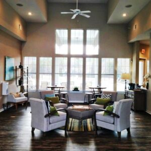 A wide, open room with lots of windows and dark, hand-textured wood floors.