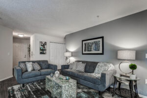 A stylish living room with beautiful light blue couches and a nice rug.