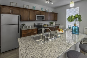 A kitchen with dark cabinets and granite countertops.