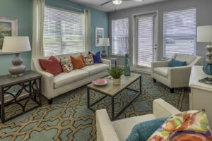 A stylish living room with white couches and colorful pillows