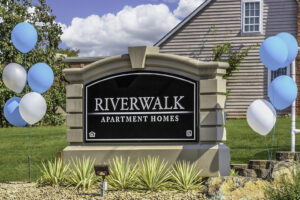 The beautiful sign at the entrance to the Riverwalk Apartments.