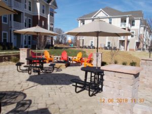 A half circle of chairs sits around a fire pit at the Riverwalk Apartments.