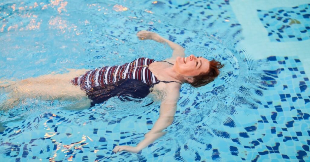 A woman rests and swims in a pool.