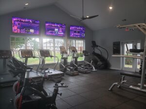 A selection of exercise equipment with TVs in front.
