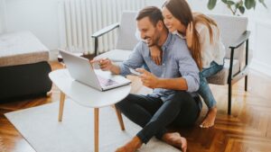 happy couple looking at laptop