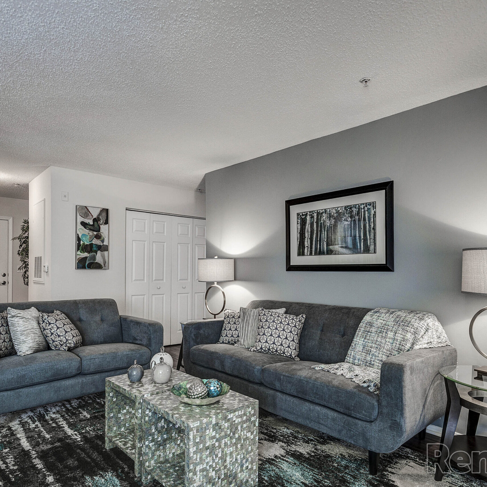 A stylish living room with beautiful light blue couches and a nice rug.