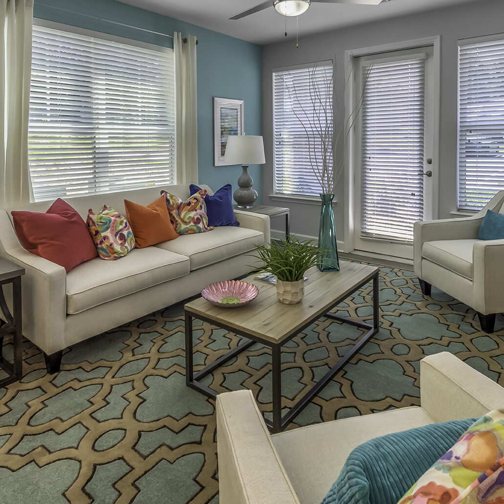 A stylish living room with white couches and colorful pillows