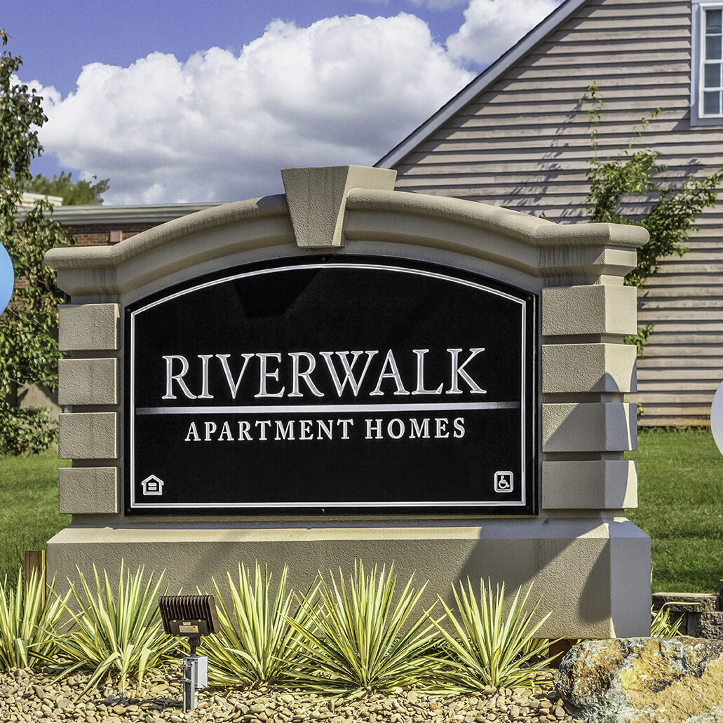 The beautiful sign at the entrance to the Riverwalk Apartments.