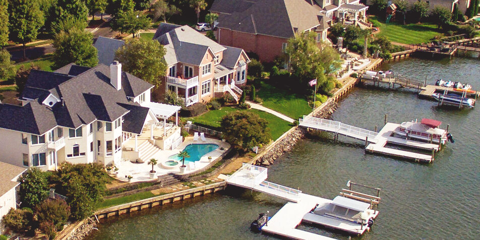 A selection of high end homes stand side-by-side by the lake water..